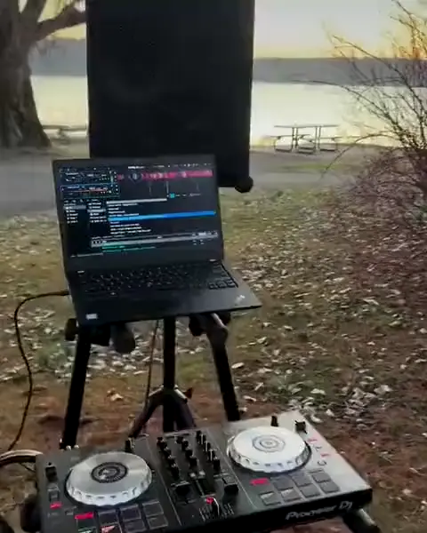 SOUNDBOKS speaker and DJ controller set up by a lake at sunset